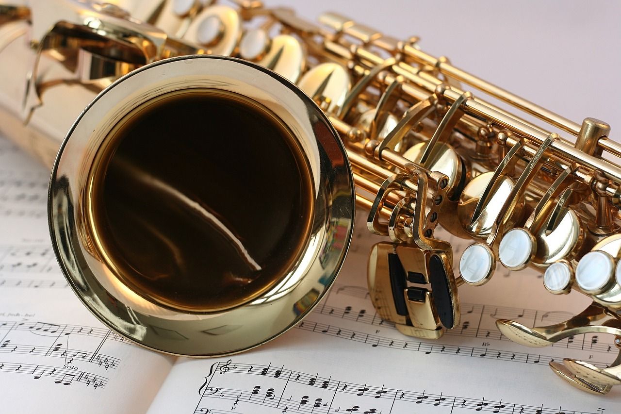 A gold saxophone on top of sheet music